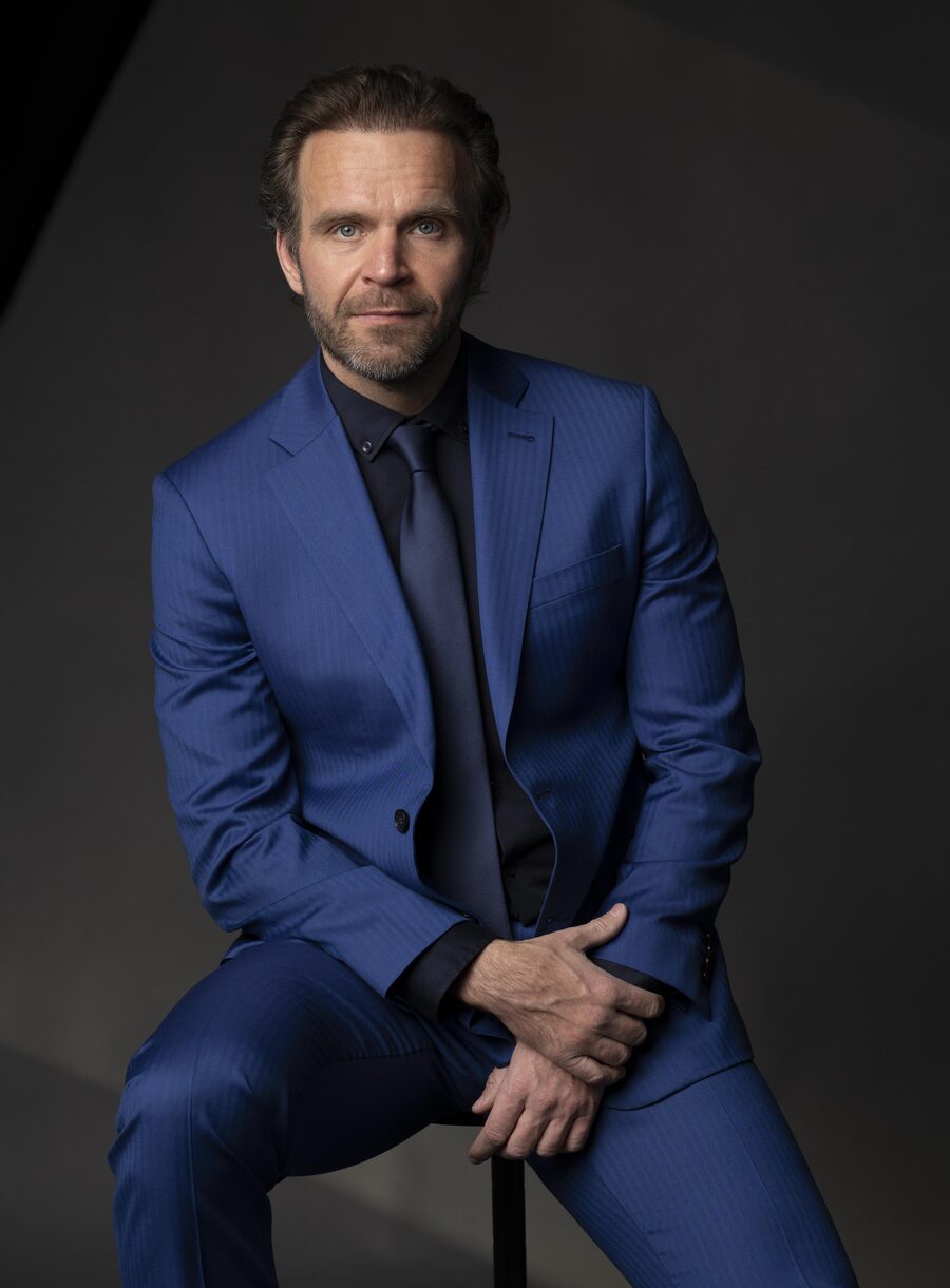 Jack Borkowski, seated, in a blue suit against a dark background, looking into the camera.